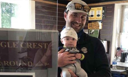 New Eagle Crest Golf Club owner Scott Battiste holds son Archie in the pro shop. The 34-year-old from Niskayuna went from head pro to owner last September