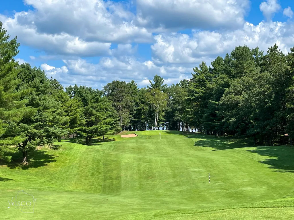 The ninth is a fun, scenic finish to the 9-hole loop at Plum Lake, with the lake visible through the trees beyond the green