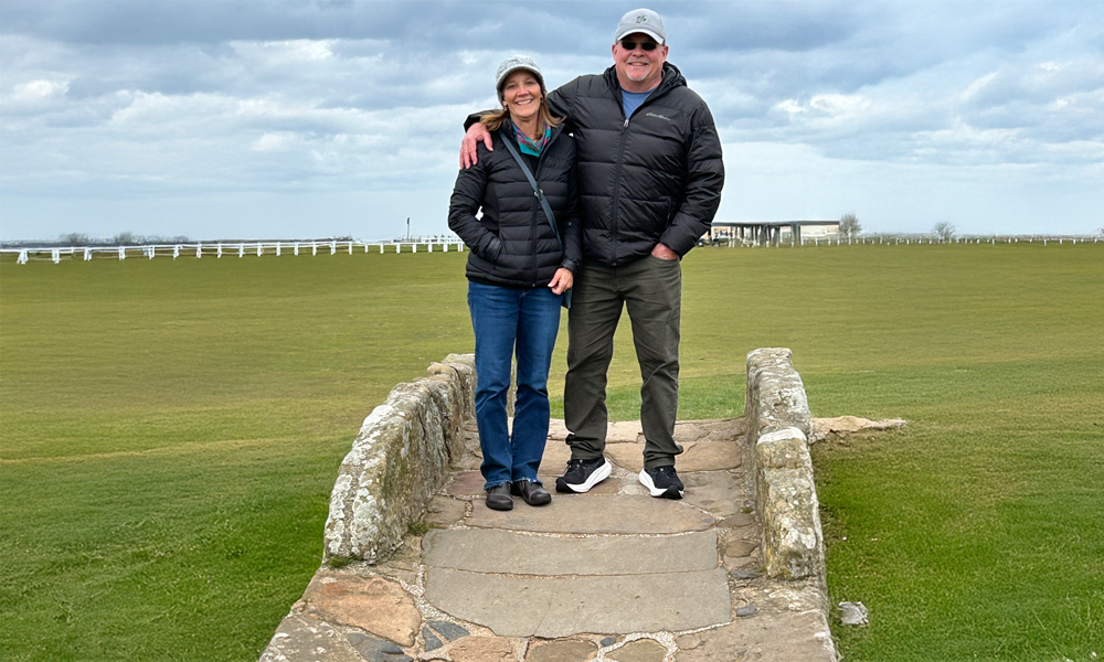 Karen & Mark Miller Pose on the Swilcan Bridge and the Old Course