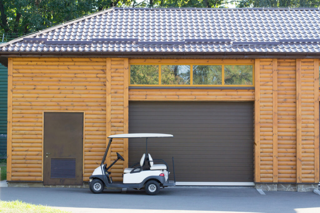 Golf carts Golf cars near the wooden garage with windows and door